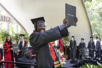 Student holding diploma at Commencement for Class of 2022