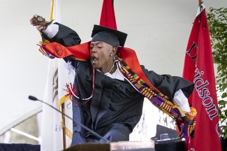 Student jumping on stage at Class of 2022 Commencement