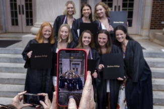 Someone holding phone and taking picture of group of graduates at Class of 2022 Commencement
