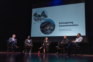 Unveiling of the Commemoration Design - Panelists on Stage with Reimagining Commemoration slide in the background