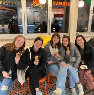 a group of five young women holding ice cream cones in a shop