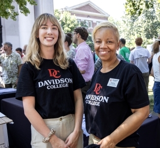 a young white woman and a middle aged Black woman stand together smiling