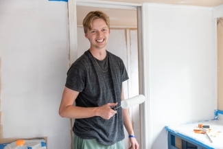 Smiling student holding paint roller