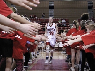 Basketball player high-fiving spectators, photo by Bill Giduz
