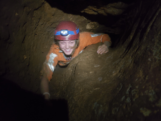 a young woman climbing in a cave