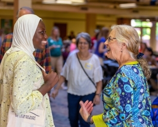 a young woman talks to an older woman smiling
