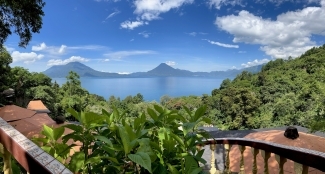 a tropical view of an island with ocean and mountains in the background