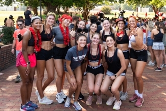 a group of young women in running clothes stand together