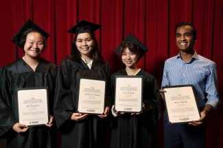 a group of four young people holding awards