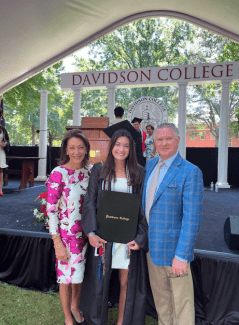 parents with their daughter at her graduation in regalia