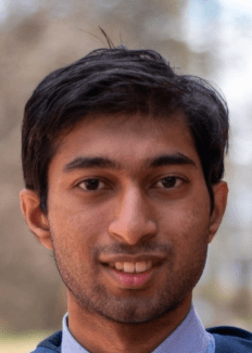a young man with dark brown hair wearing a collared shirt