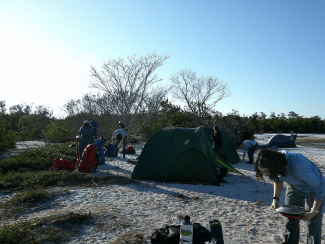 a campsite on a beach at sunrise