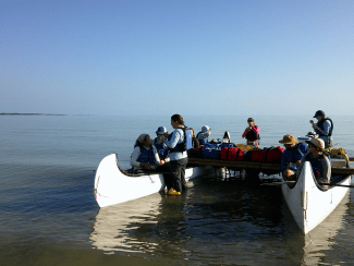 two canoes bound by bamboo sticks on an open body of water