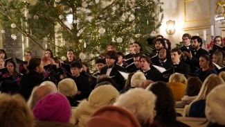 a group of young people singing in all black at winter time