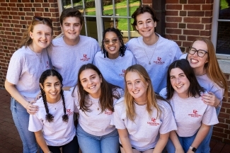 a group of young people standing together wearing "Davidson college" tshirts