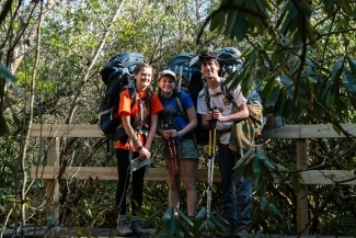 a group of young people hiking in the woods