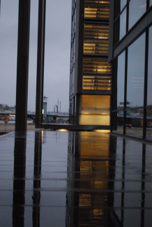 a modern black building lit up at dusk