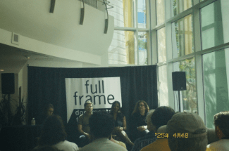 a panel of documentarians speak in a light-filled atrium