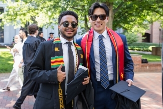 Commencement 2025 two grads give a thumbs up