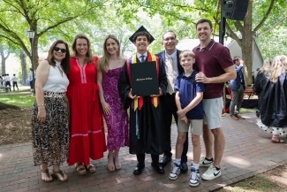 Commencement 2025 family poses together with their grad