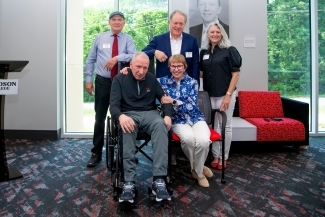 five older people sit and stand together in a modern athletic space