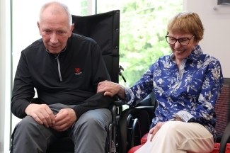 an older white couple sits together smiling