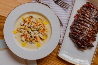 a table of food including a soup and steak