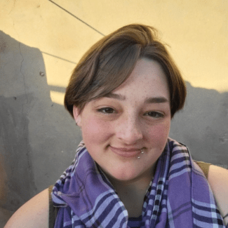 a young woman with short brown hair wearing a scarf