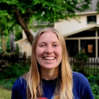 a young white woman with blonde hair wearing a blue tshirt
