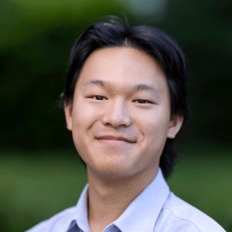 a young man with dark hair wearing a collared shirt