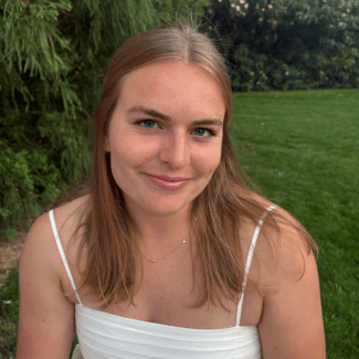a young white woman with blonde hair wearing a white dress outside