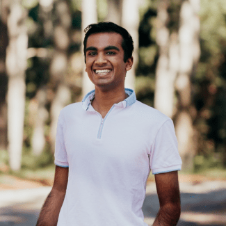 a young man wearing a collared shirt standing outside