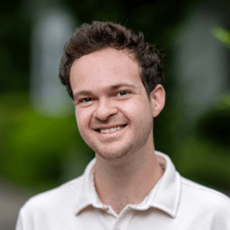 a young white man with brown hair wearing a collared shirt
