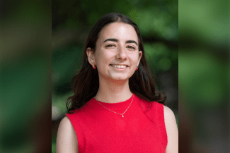 a young white woman with dark hair wearing a red sweater