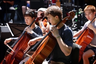a group of students play instruments outside on a sunny day