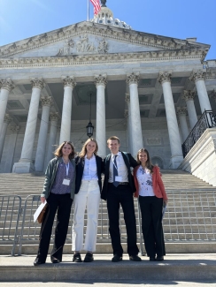 a group of four young people stand in business casual in D.C.