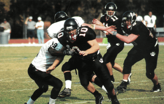 a group of young men play football in black and white uniforms at night