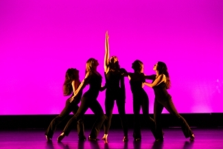 a group of young people dancing in front of a hot pink background