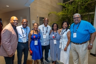 a group of people stand together in an academic building during reunion weekend