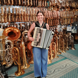 a young woman holding an accordion in a music instrument shop