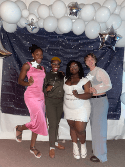 a group of young people posing in front of a photo backdrop at a school dance