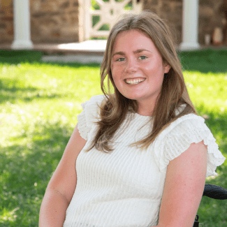 a young woman with blonde hair wearing a white dress on a sunny day