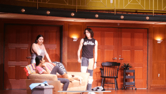 three young people sitting around on a stage 