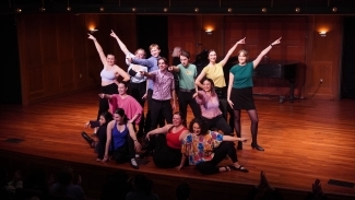 a group of young people smile and pose on a stage
