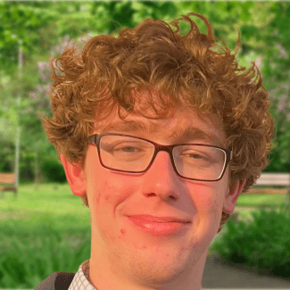 a young man with curly blonde hair wearing glasses
