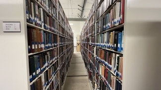 Looking between two rows of long bookshelves