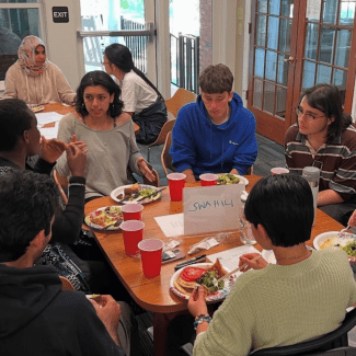 a group of students sitting around a table talking