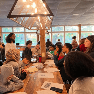a group of students sitting around a table having a conversation