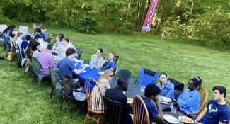 Students eating outdoors at a very long table