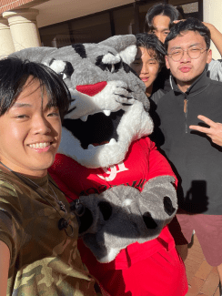 a group of college students smile together while taking a selfie
